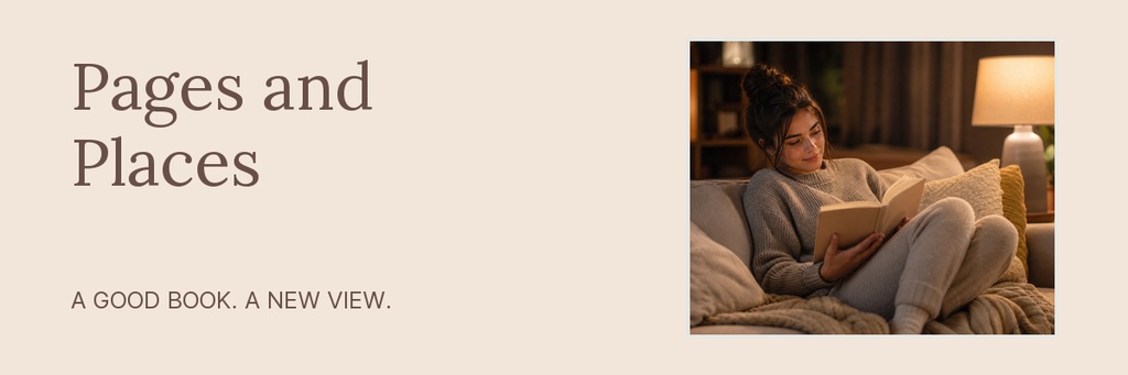 Woman reading a book on a sofa beside a glowing lamp in a cozy room.