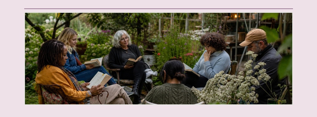 People seated in a garden circle with flowers and greenery around them